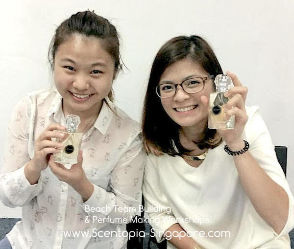 two female showing their DIY perfume bottles