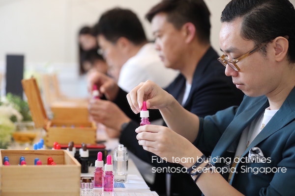 man opening orchid fragrance oil bottle with team