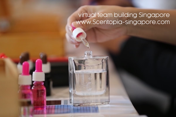 Hand dropping fragrance oil into perfume bottle