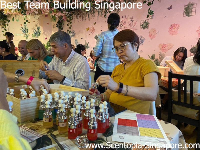 a group of people making their signature orchid scent at scentopia