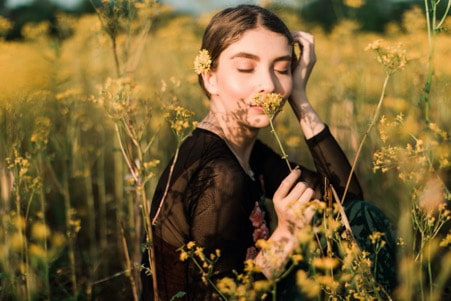girl smelling aroma of a flower